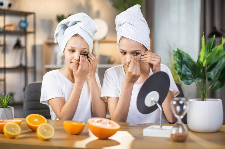 Two girls applying skincare with fruit slices and towel-wrapped hair at home, enhancing beauty routines naturally