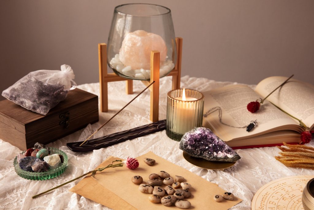 A table displaying an assortment of crystals, candles, and books arranged artistically