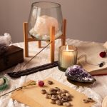 A table displaying an assortment of crystals, candles, and books arranged artistically