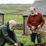 Two men tending to plants in a lush garden, engaged in gardening activities